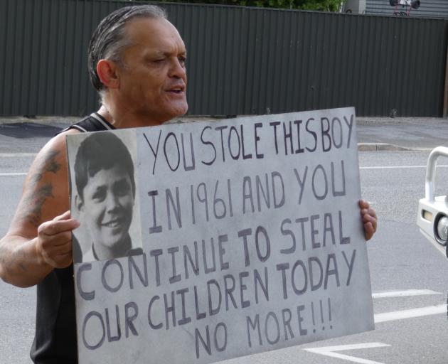 Alexandra man Tony Jarvis holds a placard outside the town’s Oranga Tamariki office describing...