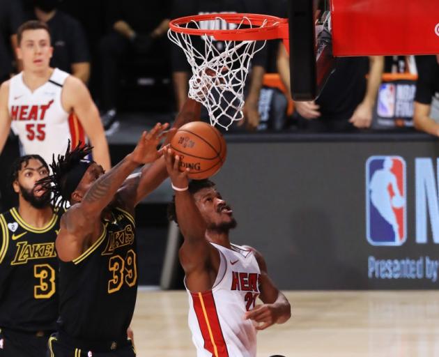 Miami Heat forward Jimmy Butler takes the ball to the hoop as Los Angeles Lakers centre Dwight...
