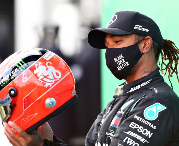 Lewis Hamilton is presented with a helmet of Michael Schumacher's as he ties his record for most...