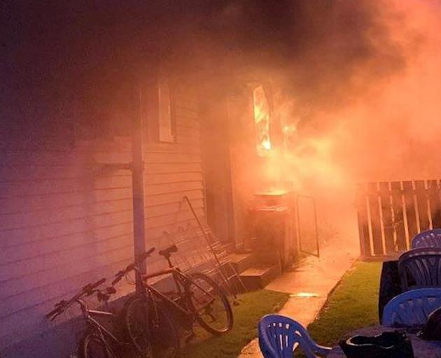 Flames and smoke pour out of the Fashwal family’s house in Oban St, Mosgiel, during a blaze that...