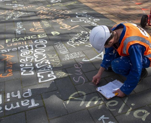 Artist Bruno Willis chalks names in the Octagon, highlighting the people whose lives have been...