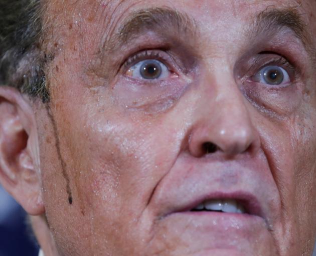 Rudy Giuliani, personal attorney to US President Donald Trump, speaks as sweat runs down his...