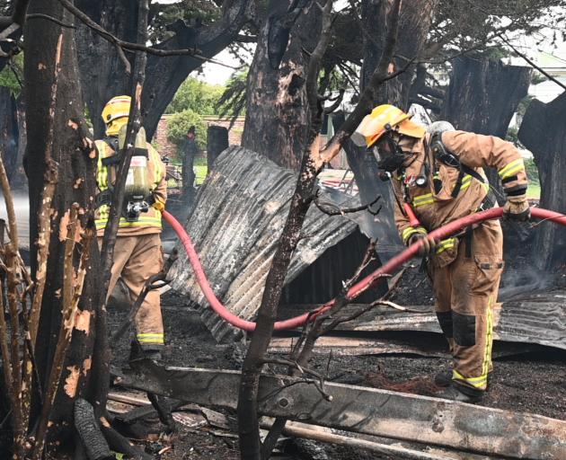 Firefighters work to dampen down hot spots around a major house fire in Portobello. Photo: Craig...