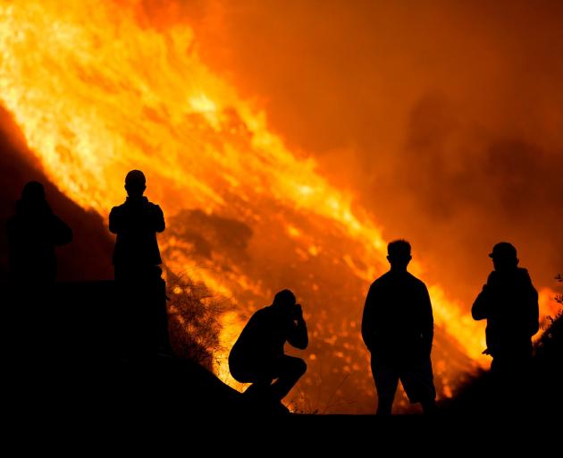 Residents are silhouetted as they watch the Blue Ridge Fire burning in Yorba Linda, California....
