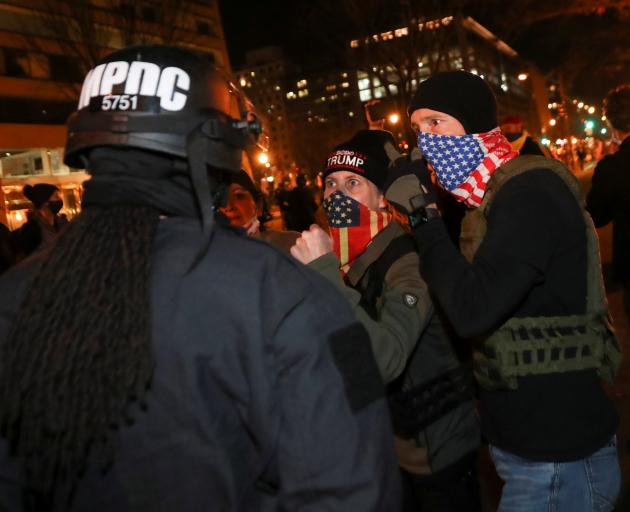 Supporters of President Donald Trump argue with a police officer during a protest in Washington,...