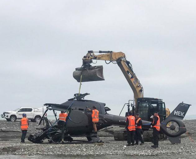 The wreckage of the helicopter is removed from Kēkerengū Beach. Photo: Anna Leask