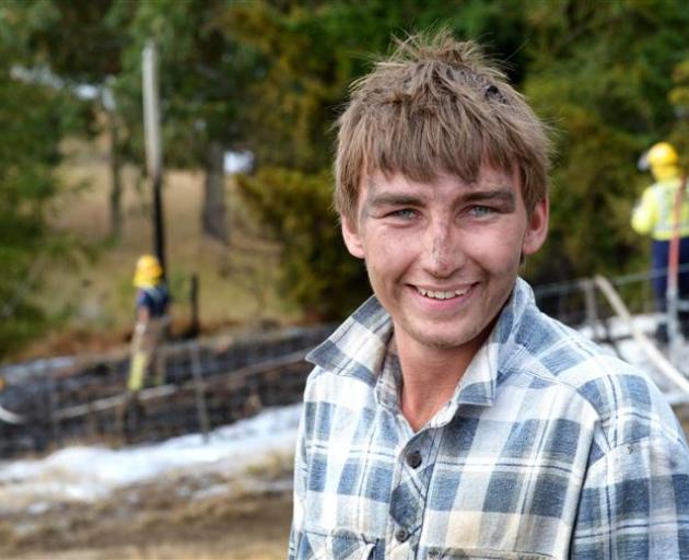 Jake Bridson relaxes after helping battle a grass fire near Clarks Junction yesterday. Photos by...
