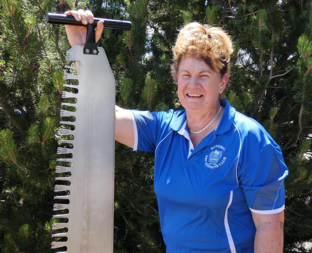 Mrs Taylor shows off the single-handed saw, which is but one of the tools she uses as she...