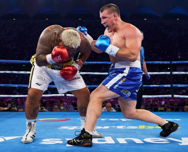 Paul Gallen (right) attacks against Mark Hunt during his upset boxing win last night. Photo:...