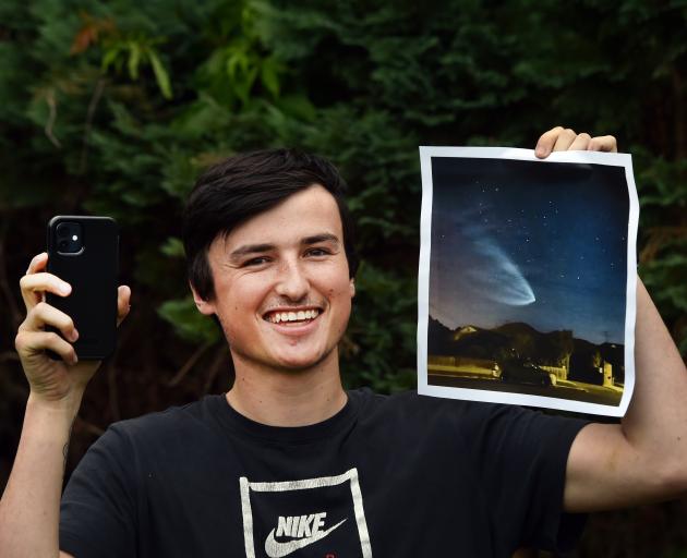 Mosgiel resident Finn Carter holds his photo of a Rocket Lab electron rocket, flying into orbit...