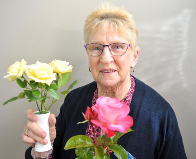 Otago Rose Society double Champion of Champions winner Wilma Graham holds her two champion roses,...