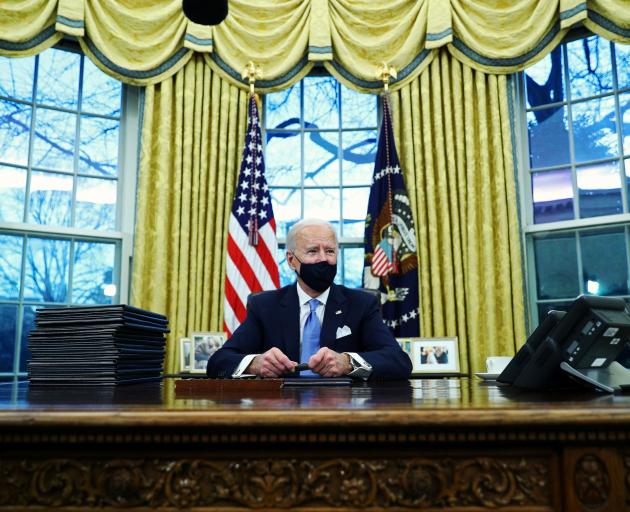 US President Joe Biden signs executive orders in the Oval Office of the White House yesterday....