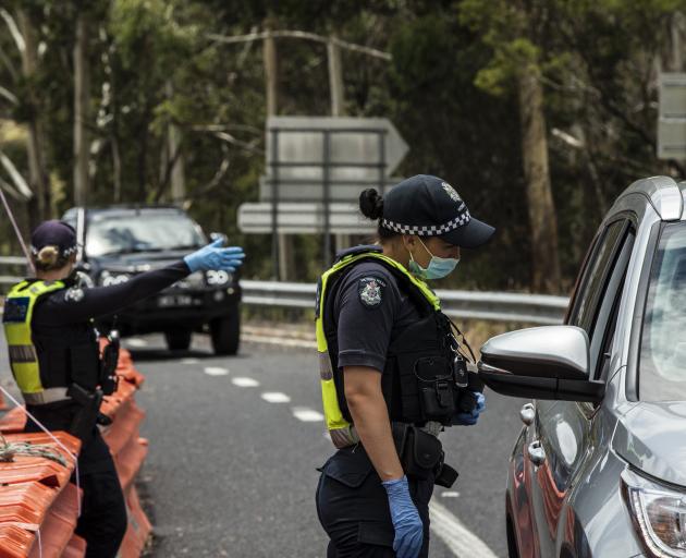 Police check for entry permits to Victoria at a border checkpoint last month. PHOTO GETTY IMAGES