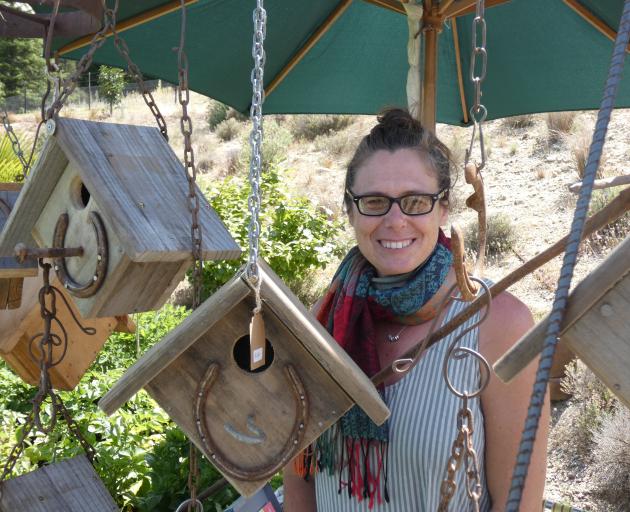 Ettrick artist Vauna Turner stands among some of the bird houses she has crafted from fruit...