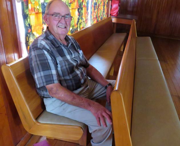 Carl Ruddenklau with two of the church pews that are now surplus to requirements. Photo: Supplied