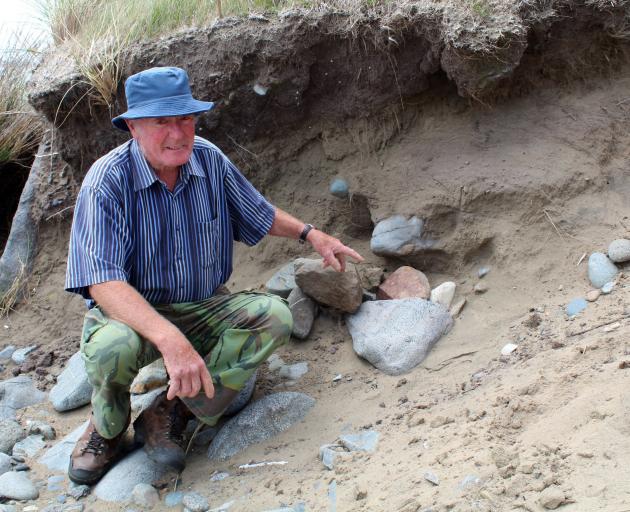 Beachcomber Alan Clark, of Greenhills, points to the pile of rocks which now covers the spot...