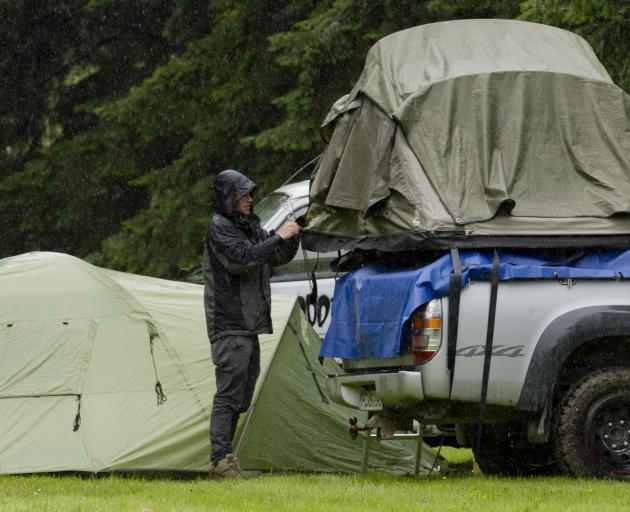 A festival-goer packs up his tent and prepares to leave Whare Flat earlier this afternoon. Photo:...