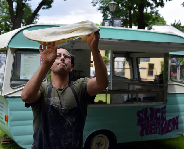 Slice of Heaven owner Gareth West throws pizza dough in the air on the Otago Museum lawn in North...