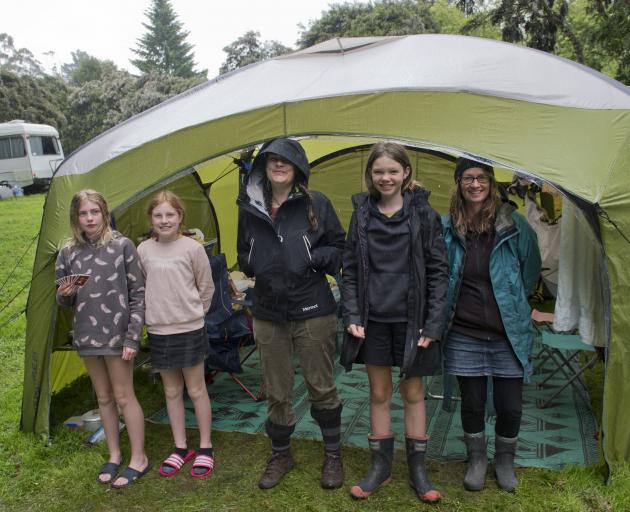 Staying dry in their tent at the folk festival on Saturday are (from left) Asheika (12), Katiya ...