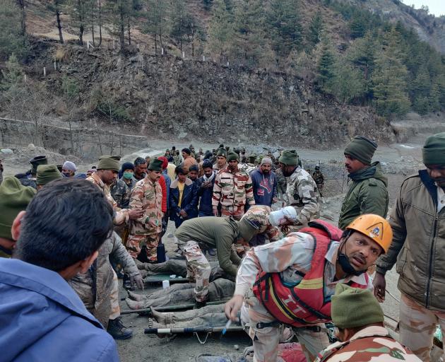 Members of Indo-Tibetan Border Police tend to people rescued after a Himalayan glacier broke and...