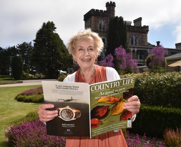 Larnach Castle owner Margaret Barker holds a copy of British magazine Country Life which features...