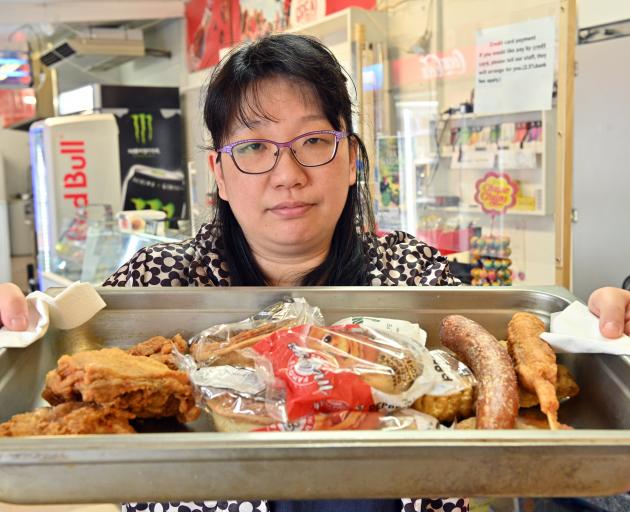 East Taieri Dairy and Takeaways owner Crystal Cao with a tray of food, typical of what she has...