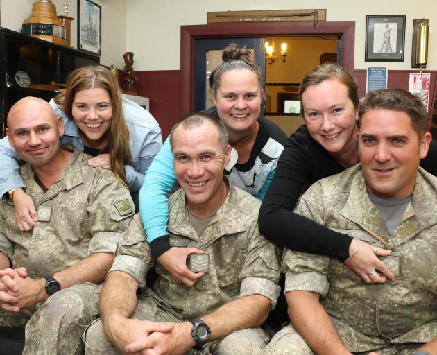 Helping their husbands attach their new senior non-commissioned officers ranks on to their...