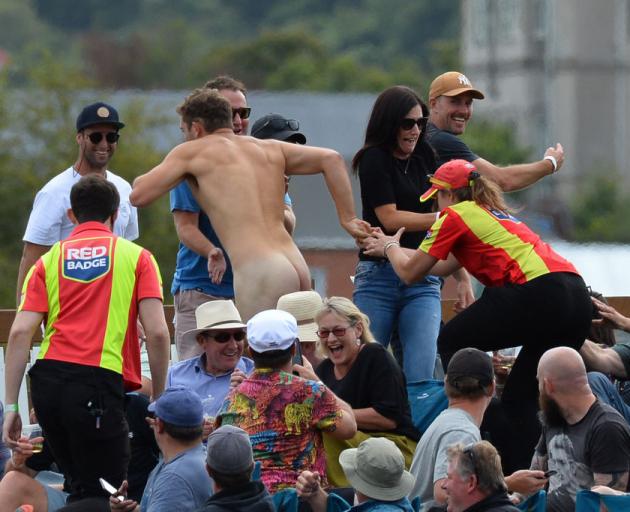 Members of the ground security try to catch a streaker during the second Twenty20 international cricket match between New Zealand and Australia at University Oval in Dunedin. Photo: Getty Images