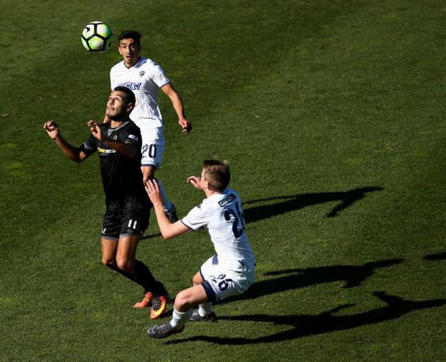 Mario Barcia of Team Wellington controls the ball under pressure from Callum McCowatt and...