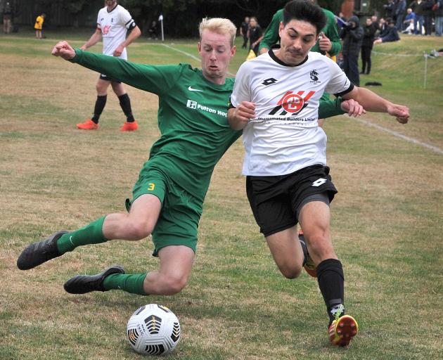 Green Island’s Aaron Allan seeks to knock the ball away from Roslyn Wakari’s Karma Gyeltshen...