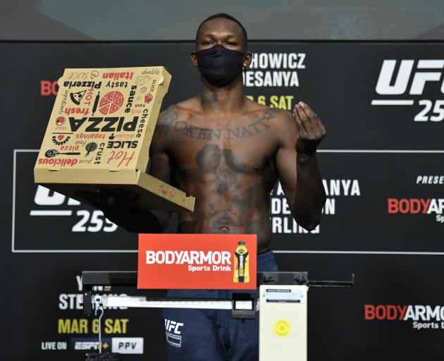 Israel Adesanya poses with a pizza box at the weigh-in for UFC 259. Photo: Getty Images