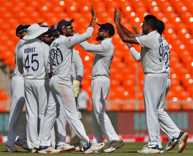 India players celebrate after taking a wicket against England during the first day of the fourth...