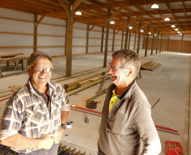 Robert Kvick (left) and John Campbell work on the new indoor curling rink in Alexandra, which is...