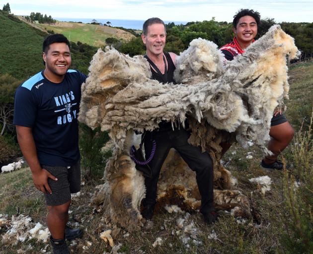 Bill Boyes (centre) holds the huge fleece he removed from a sheep, caught on Scroggs Hill by King...