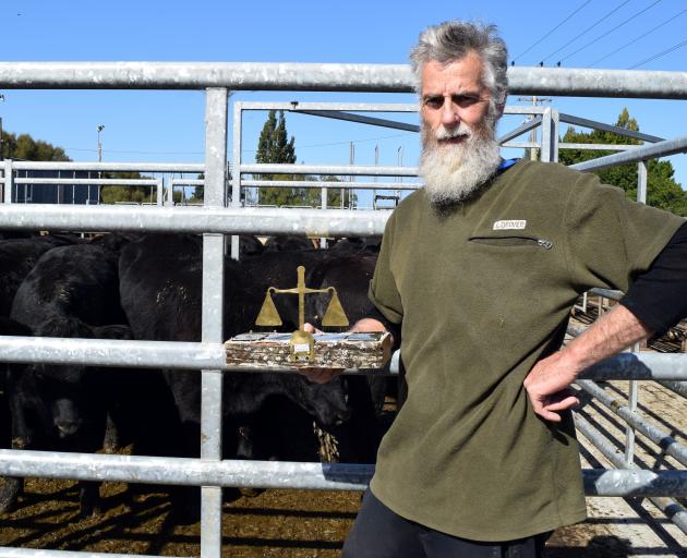 Grant Simons displays the R.B. Murray Trophy he won for having the heaviest pen of steer calves...