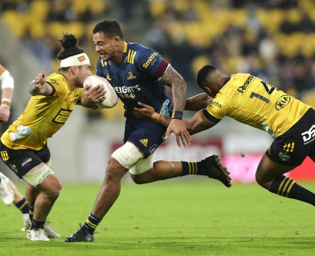 Highlanders loose forward Shannon Frizell attempts to burst through the tackles of Hurricanes...