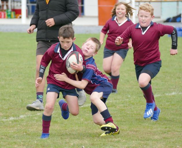 Henry Harwood (7) goes to tackle eventual try scorer Jake McHaffie (8) during an under-9s warm-up...