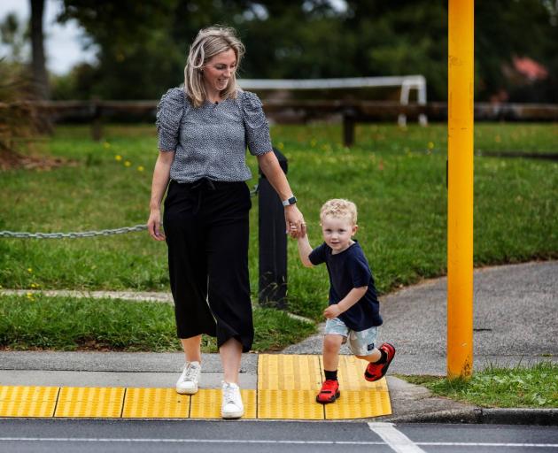 Bodie Hamilton about to cross at the signalled crossing near his home, with mum, Hayley. Despite the crash, Bodie doesn't have any fear about crossing there. Photo: Mike Scott