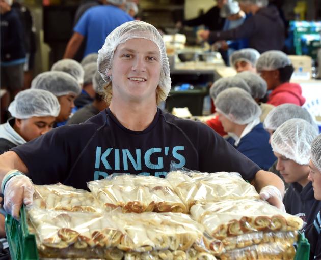 Holding some of the 44,000 individual cheese rolls made at Kings High School yesterday is pupil...