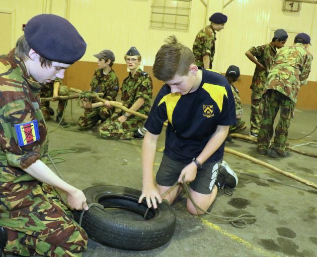 City of Dunedin Cadet Unit cadet Hunter MacDade (14, left) works with  Aaron Stoddart (15), of...