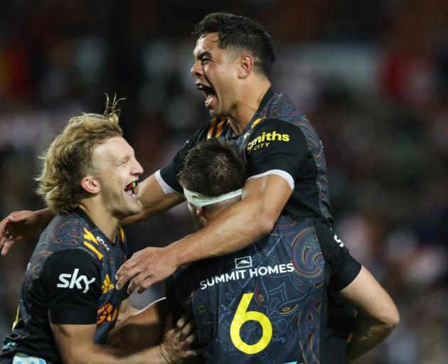 A jubilant Damian McKenzie (left) celebrates with Anton Lienert-Brown (top) and Mitchell Brown...