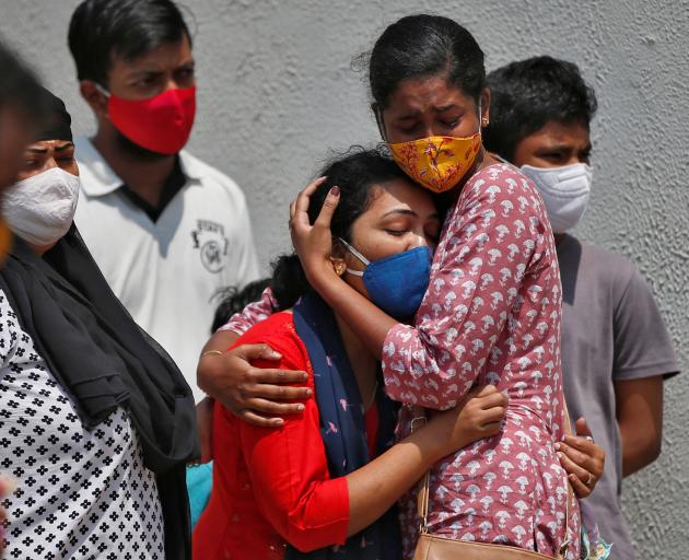 A woman is consoled after her husband died due to Covid-19 in Ahmedabad, India. Photo: Reuters