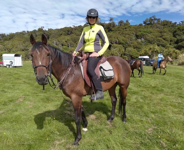 Long-time cavalcader and trail boss Jane Whitmore and her young horse Kenny near Kaka Point. Mrs...