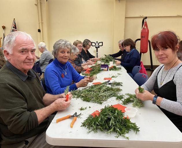 Joining volunteers at HMNZS Toroa in making about 4000 rosemary posies for Anzac Day were (from...