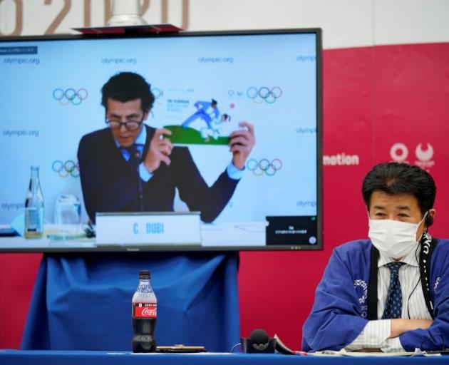 International Olympic Committee (IOC) executive director Christophe Dubi is seen on a screen as...