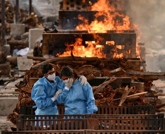 Family members of Vijay Raju, who died due to the coronavirus disease, mourn before his cremation...