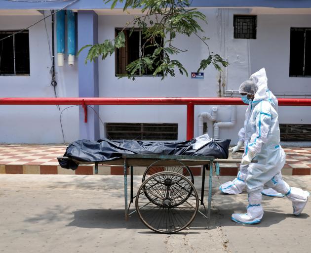 Healthcare workers transfer a body from a hospital in Kolkata on Wednesday. India accounts for...
