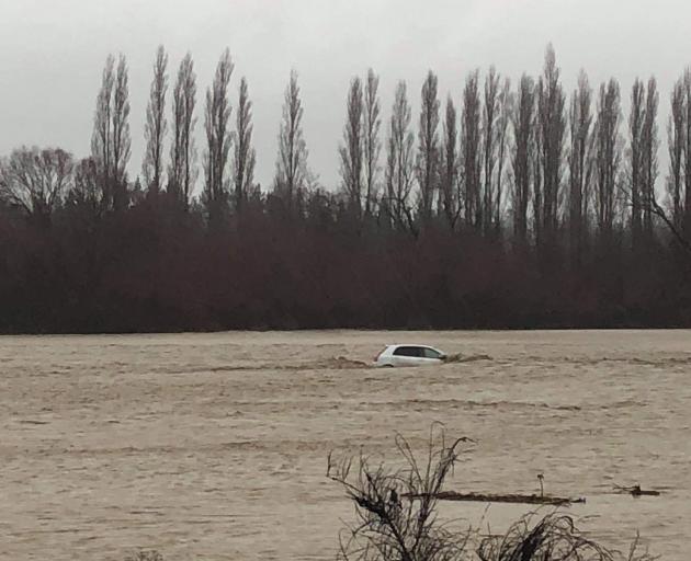 The occupants of this car managed to get out before the vehicle floated down Taylors Stream in...