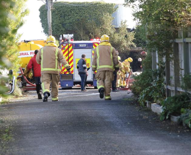 Firefighters at the scene of the house fire in Balclutha today. Photo: John Cosgrove