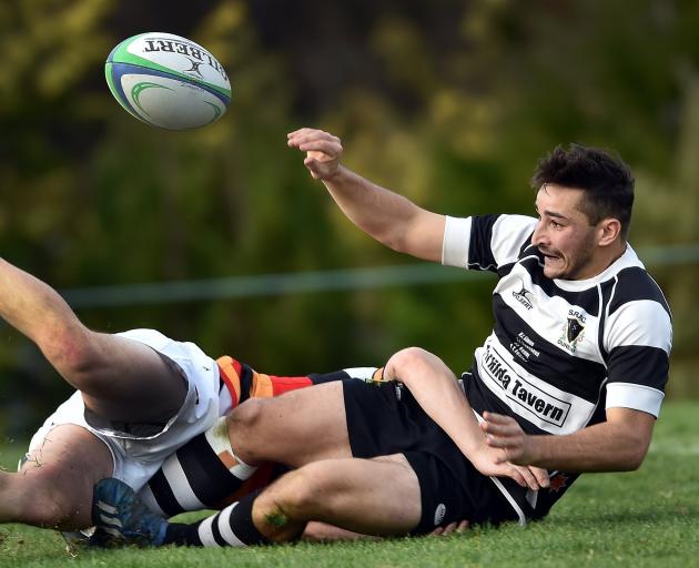 Southern halfback Wilson Driver seeks to pass the ball up in the tackle of Zingari-Richmond first...